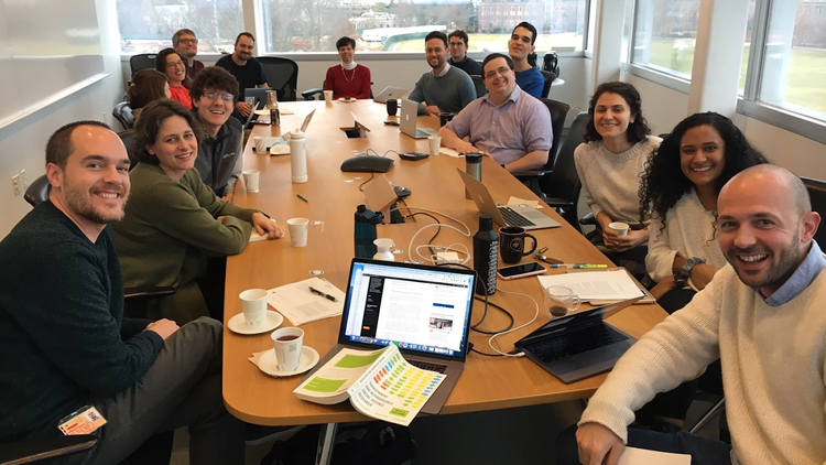 Photo of thre Princeton ReproducibiliTea journal club members sitting around a conference table and smiling at the camera
