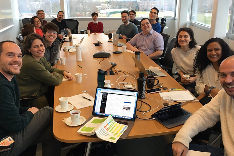 Photo of thre Princeton ReproducibiliTea journal club members sitting around a conference table and smiling at the camera