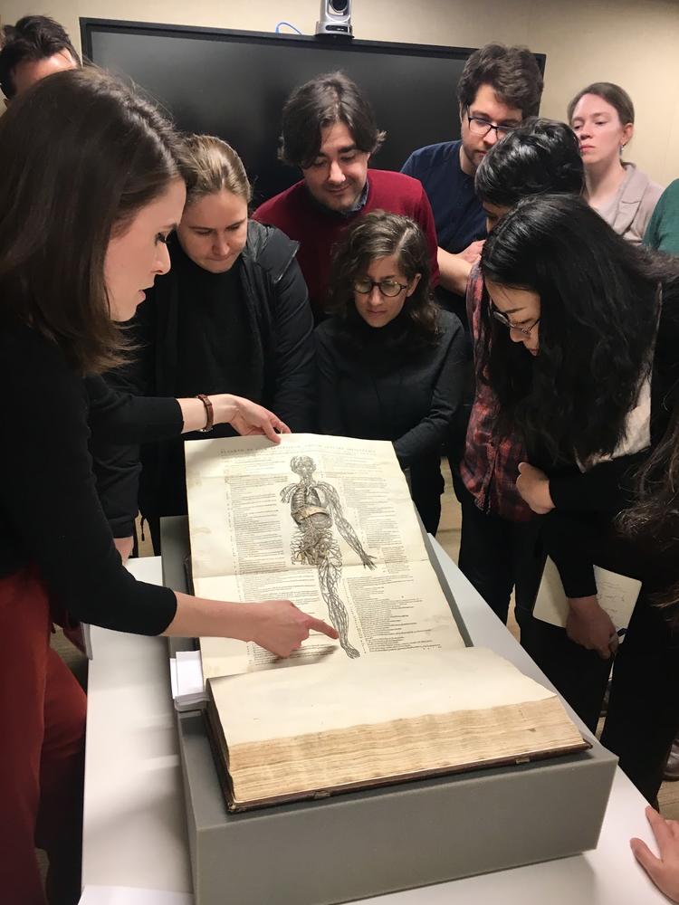 Emma Sarconi showing students an 1546 copy of De humani fabrica